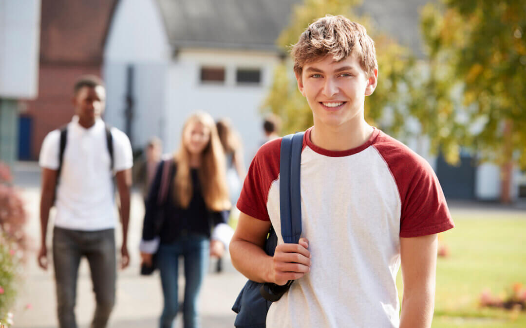 STEM student on campus smiling with a backpack