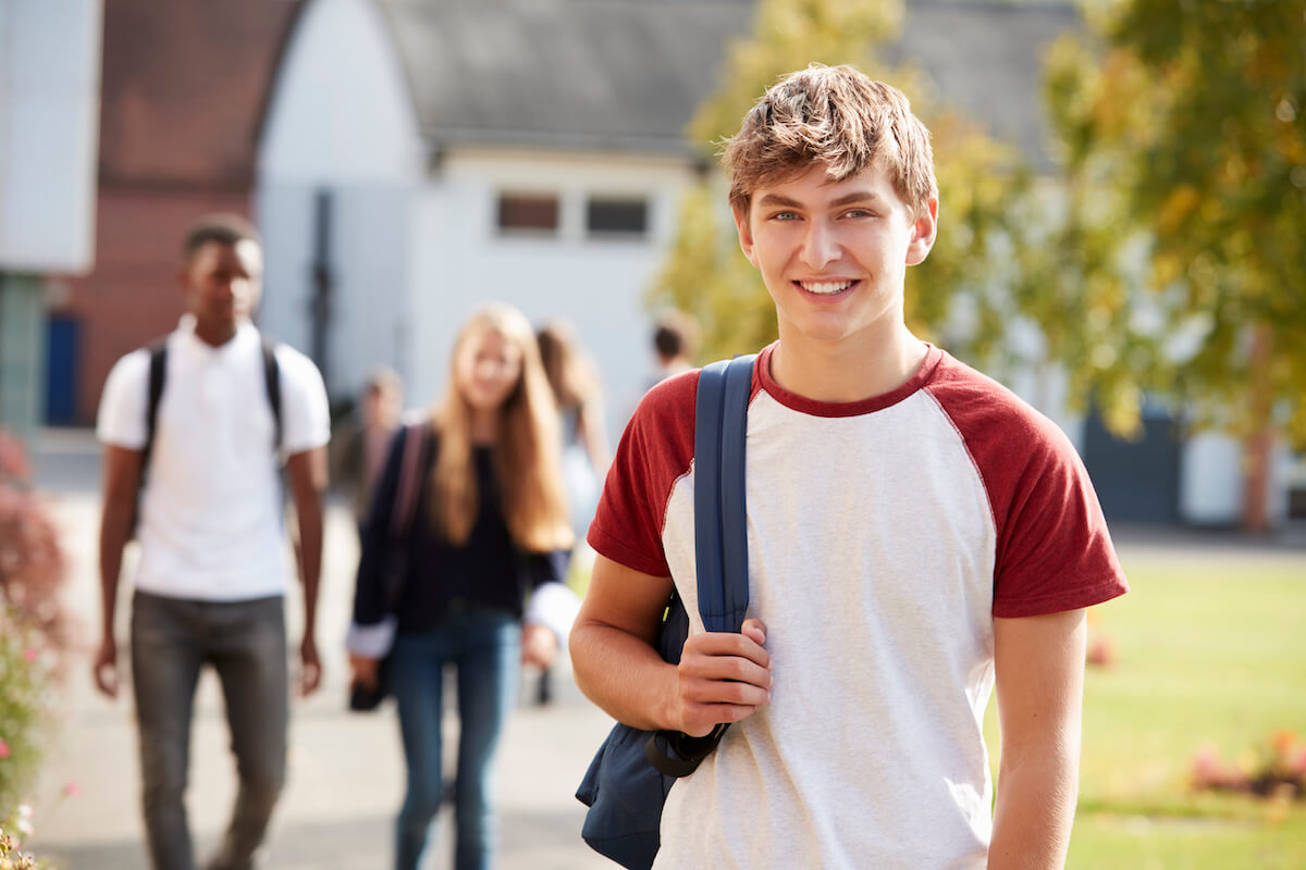 STEM student on campus smiling with a backpack